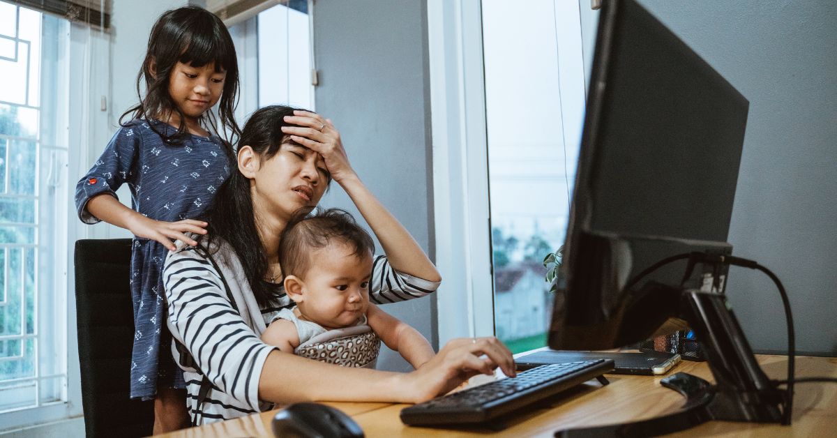 Tired woman working while taking care of two children