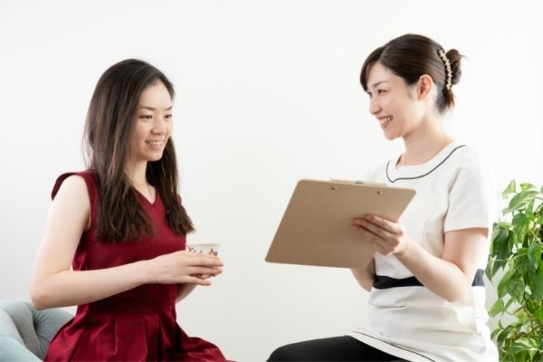 two women talking with clipboard